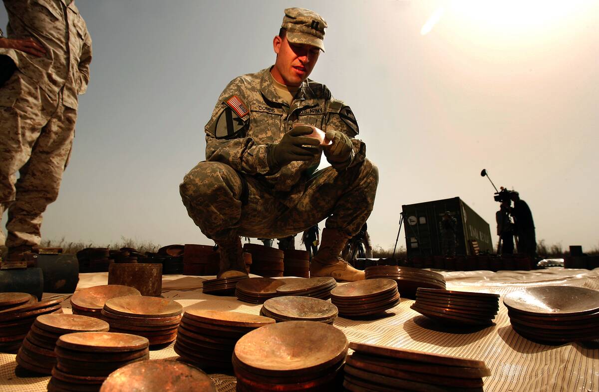 Baghdad, Iraq  U.S. Army Captain Clay Combs examines a copper plate, one of 150 found recently in